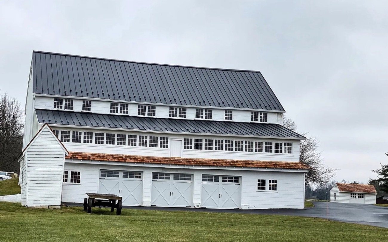 Large white barn with rows of windows